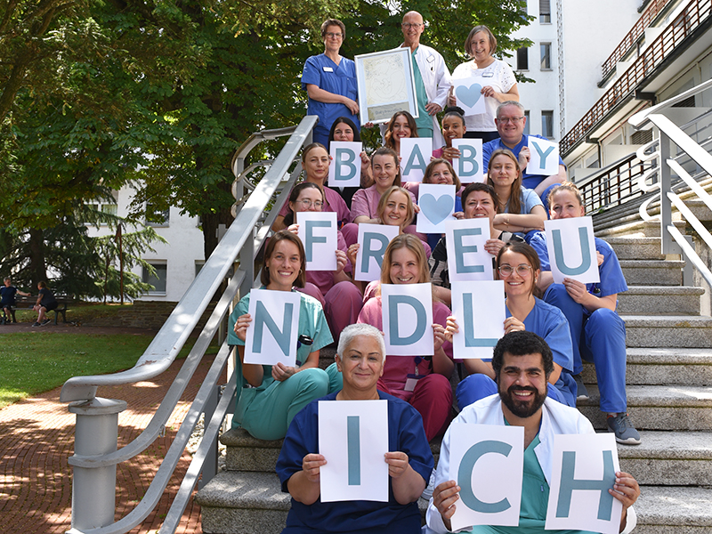Team der Geburtshilfe im Severinsklösterchen zeigt Schriftzug Babyfreundlich