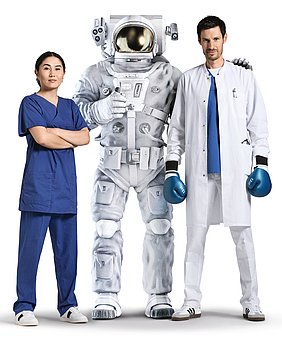 Astronaut mit Pflegerin und Arzt mit Boxhandschuhen