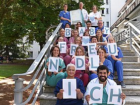 Team der Geburtshilfe im Severinsklösterchen zeigt Schriftzug Babyfreundlich