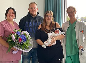 Das Team der Geburtshilfe, die Eltern und Jubiläumsbaby Lilly Marie